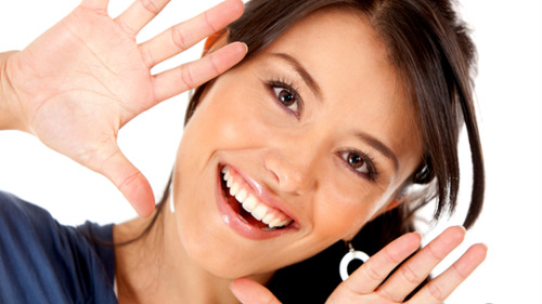 Patient smiling while displaying five fingers for a Pimpama dental consultation